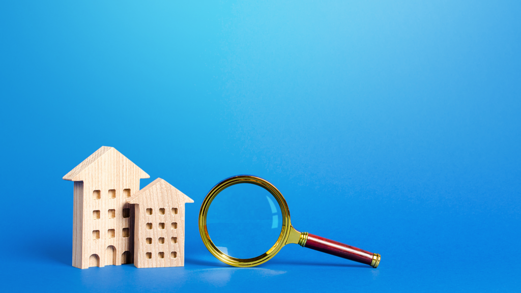Wooden homes and a magnifying glass showing the decision between renting or selling your home.